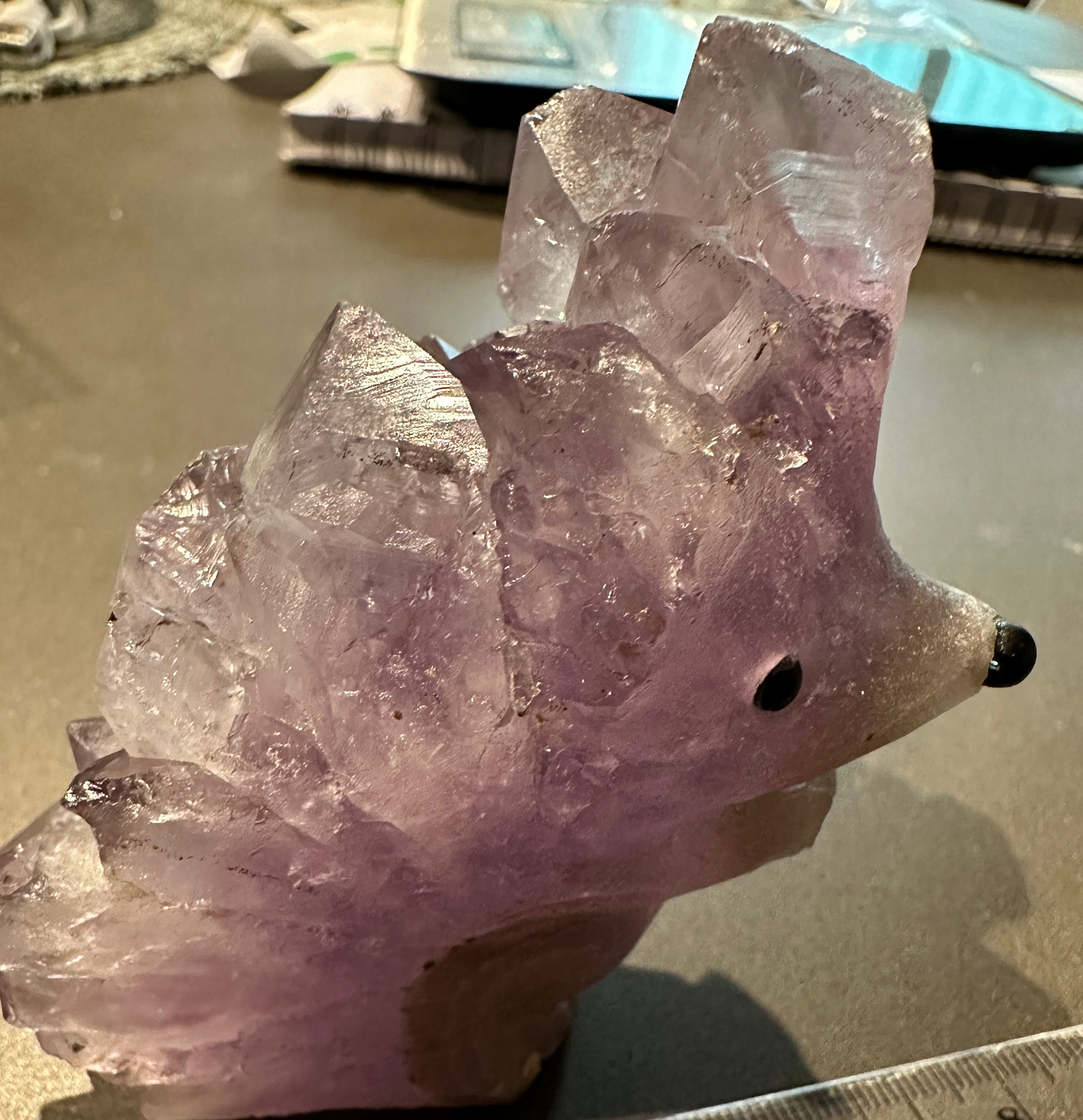 Unique hedgehog-inspired crystal carving with natural amethyst points.