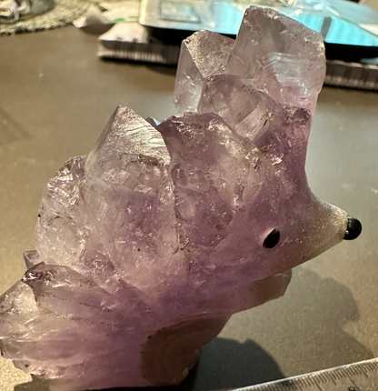 Unique hedgehog-inspired crystal carving with natural amethyst points.